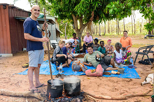 Tour group with Yolngu women, learning how to weave baskets and create shell necklaces