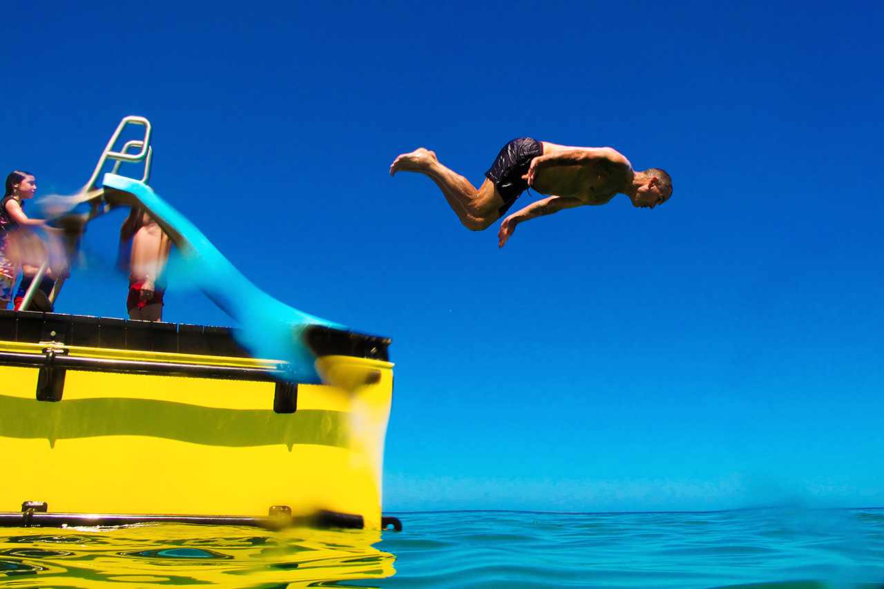 Man leaping off beach pontoon