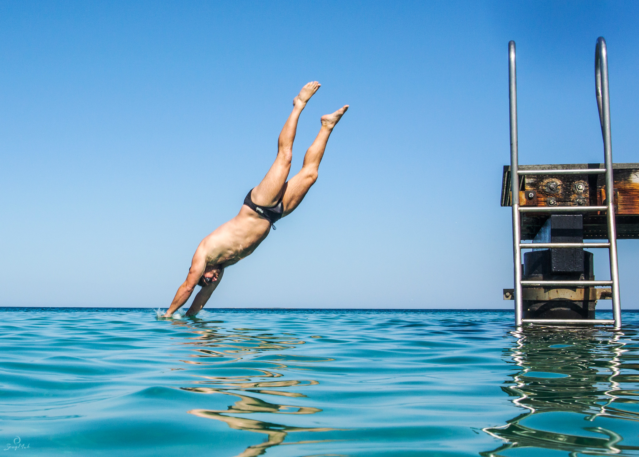 Man diving off jetty into the sea