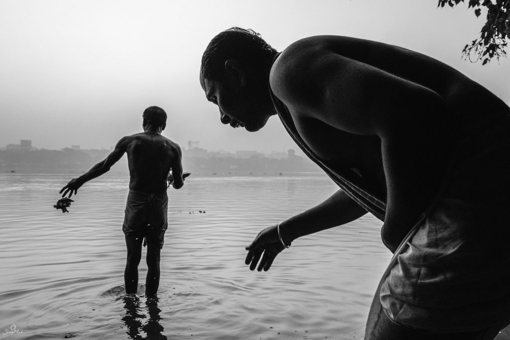 Black and white photo of morning bathers in Kolkata, India.