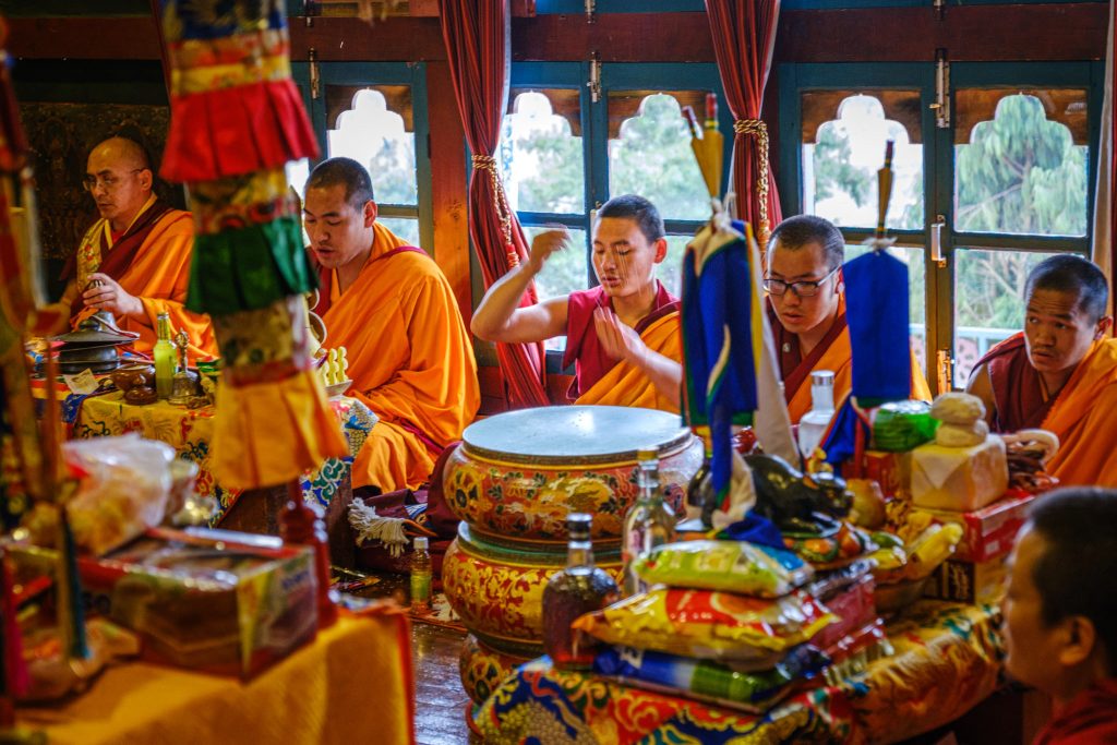 Buddhist monks in Bhutan playing instruments in a Dzong.