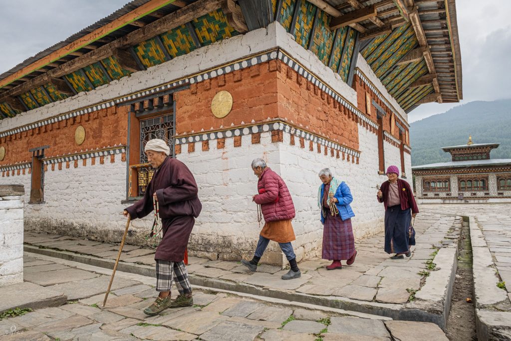 Elderly Bhutanese making a circuit around a temple.